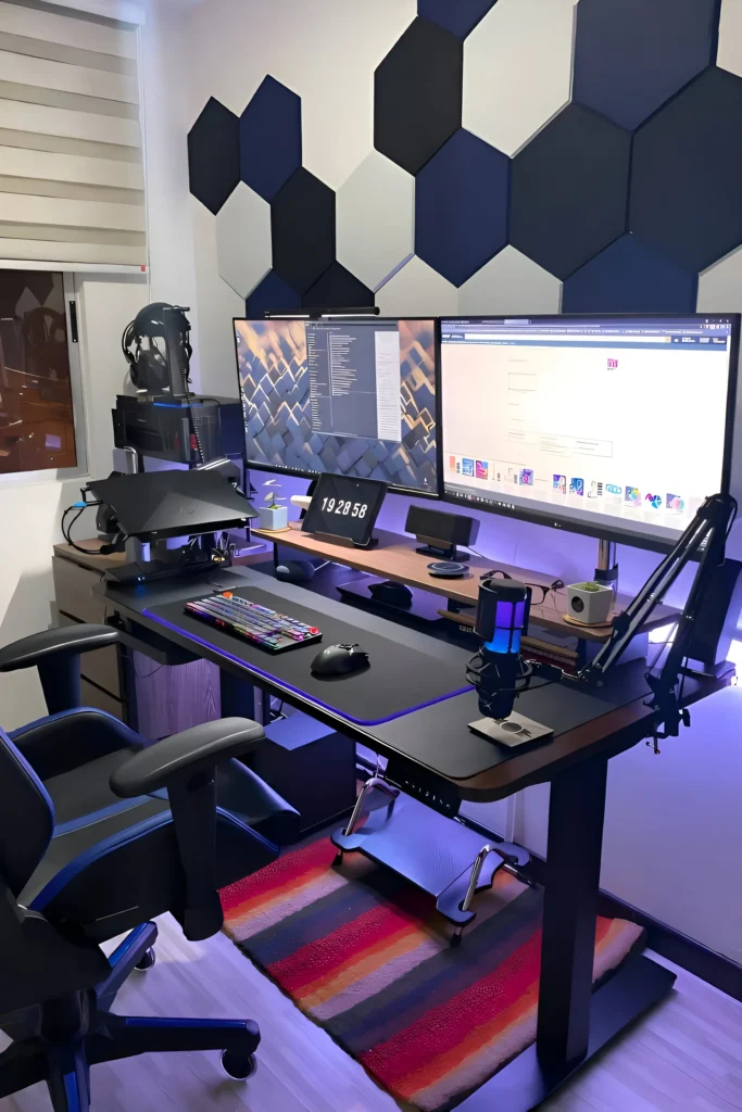 Dual-monitor workstation with hexagonal wall panels, ergonomic desk setup, RGB lighting, and modern tech accessories.