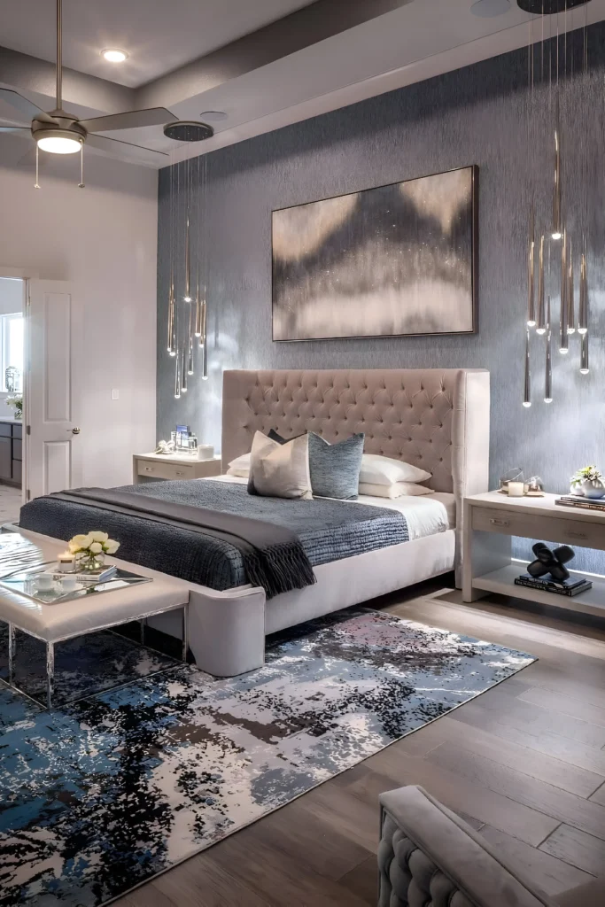 Elegant bedroom featuring cascading pendant lights, a tufted headboard, abstract rug, and neutral-toned decor for a modern and serene vibe.