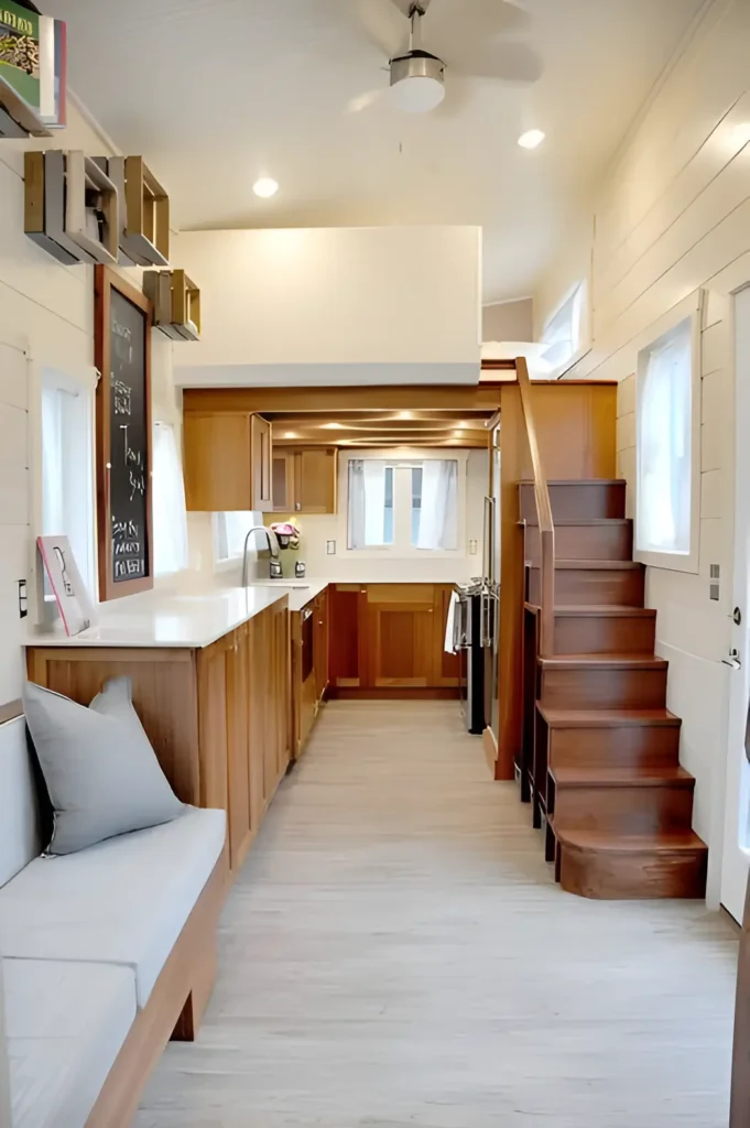 Compact loft with wooden cabinetry, built-in seating, and a cozy upper loft area.