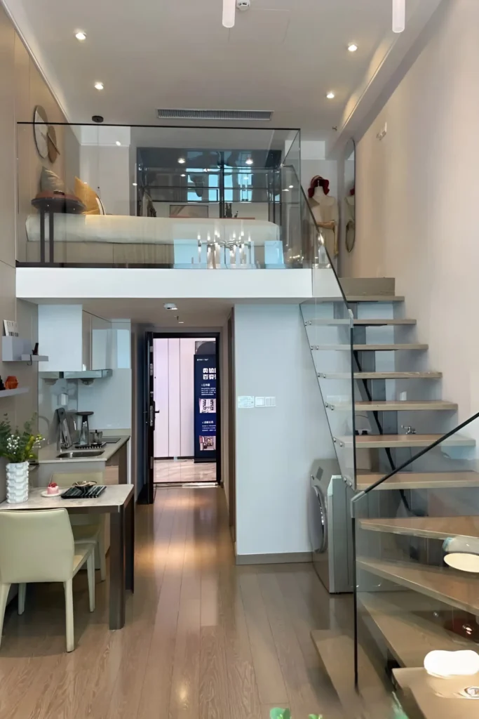 Compact loft with glass railings, a sleek staircase, and modern decor.