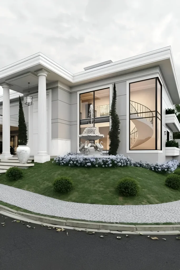 Luxury modern home with bold columns, large glass windows revealing a spiral staircase, landscaped garden, and an elegant fountain.