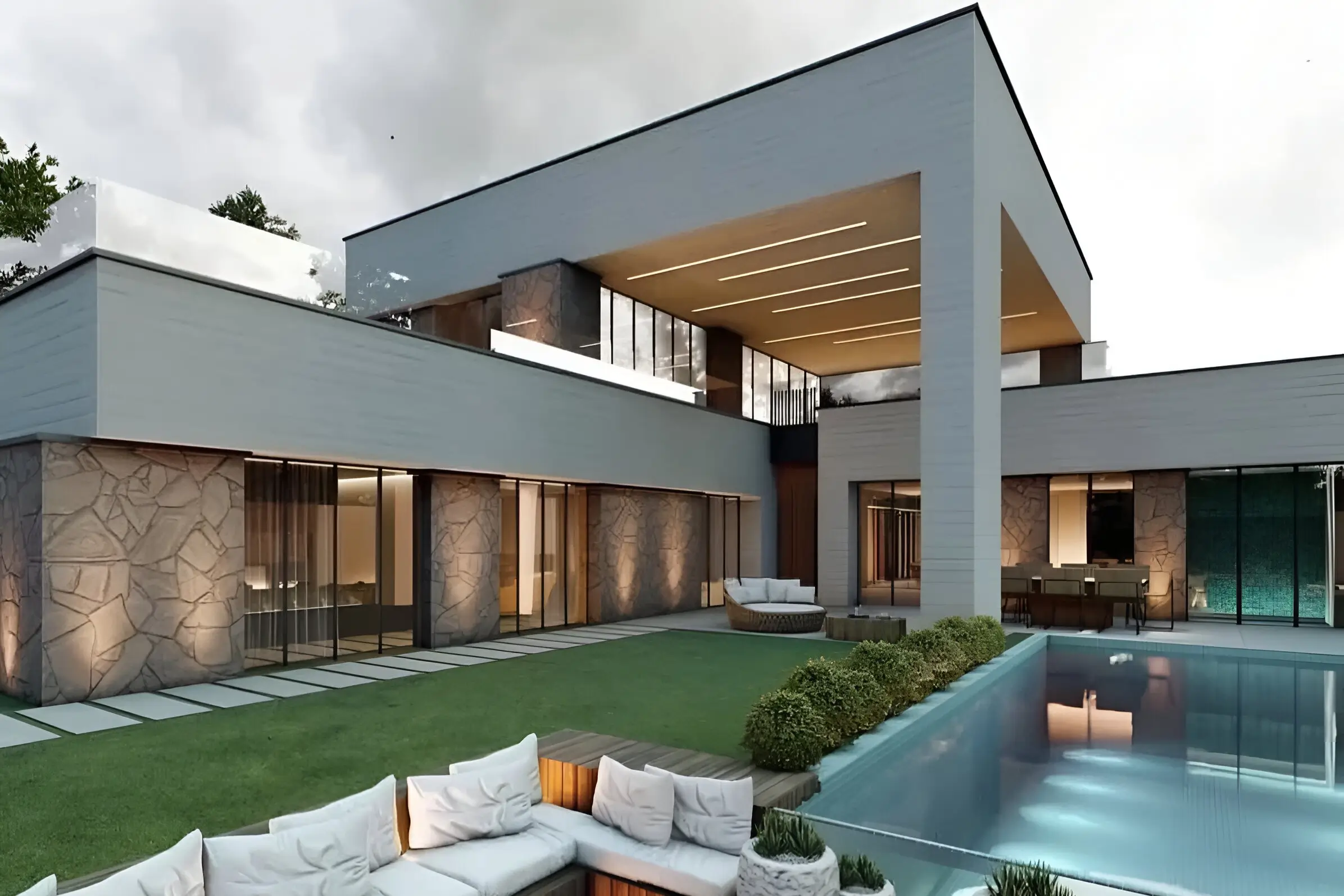 Modern home featuring natural stone textures, open layout, outdoor seating, and an infinity-edge pool.