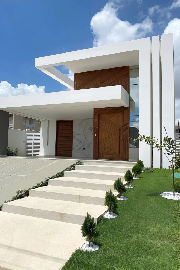 Modern house with geometric design, wooden accents, minimalist landscaping, and a tiered pathway.