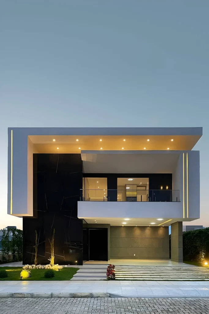 Modern house with dark and light tones, integrated lighting, glass balcony railings, and clean architectural lines.