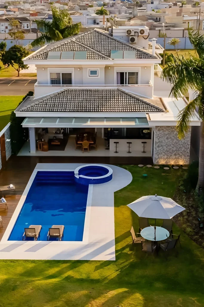 Family villa with a rectangular pool, integrated spa, outdoor patio, and palm-lined backyard.