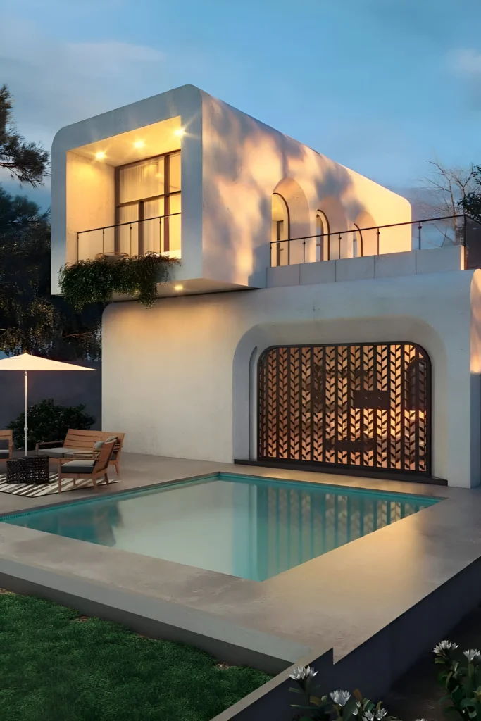 Minimalist curved villa with warm lighting, upper balcony, and an intimate pool area, complemented by stylish seating and intricate architectural details.