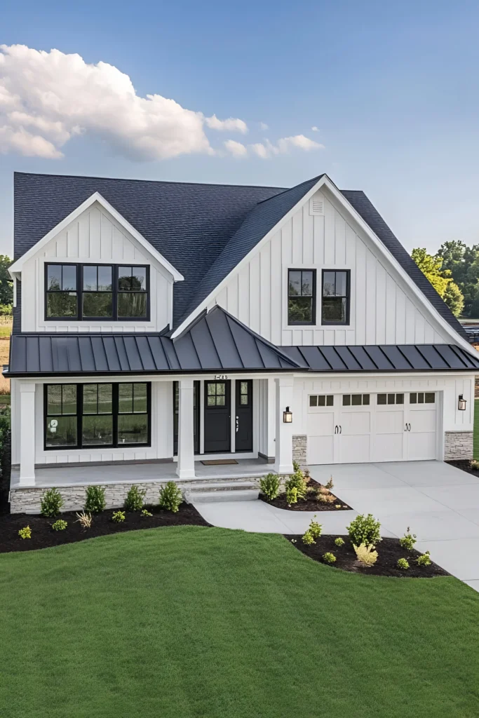 Modern white farmhouse with black-framed windows, metal roof, and landscaped front yard under a clear blue sky.