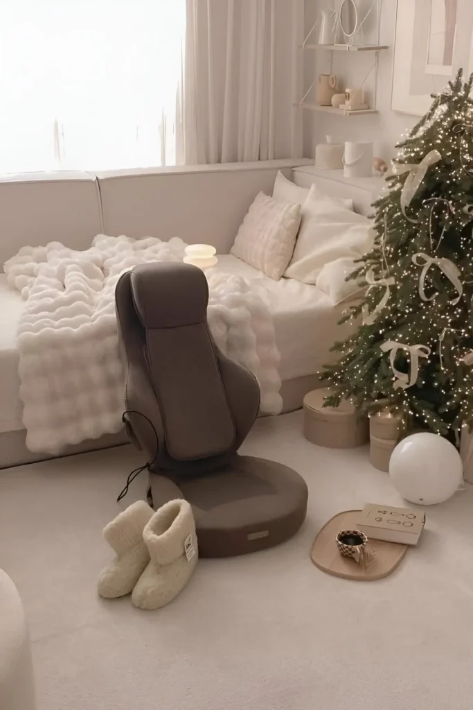 Small bedroom with white cozy bedding, minimalist decor, and a decorated Christmas tree with neutral accents.