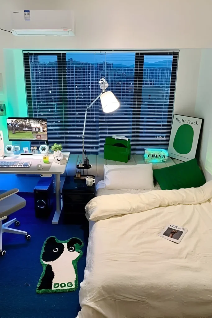 Modern bedroom with green pillows, desk setup, ambient lighting, and city view.