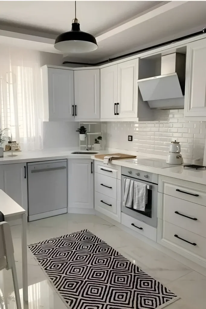 White kitchen with shaker cabinets, black handles, subway tile backsplash, and a geometric patterned rug.