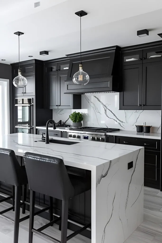 Black and white kitchen with black cabinetry, white marble island, and glass pendant lights.