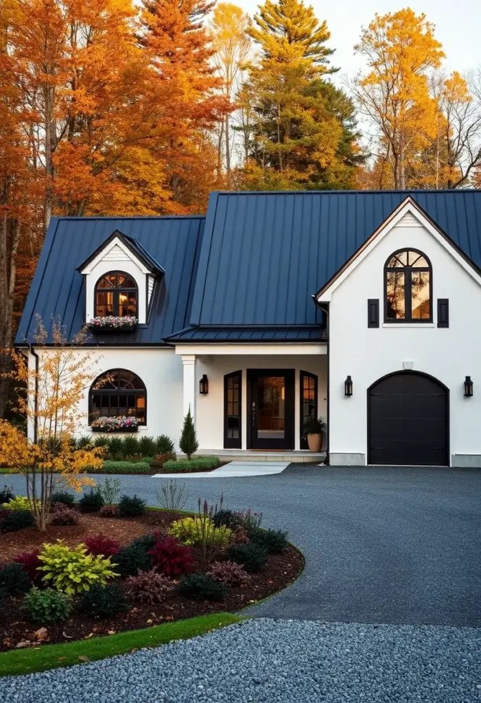 Black-and-white house with arched windows, flower boxes, sleek black roofing, and colorful landscaping in the front yard.