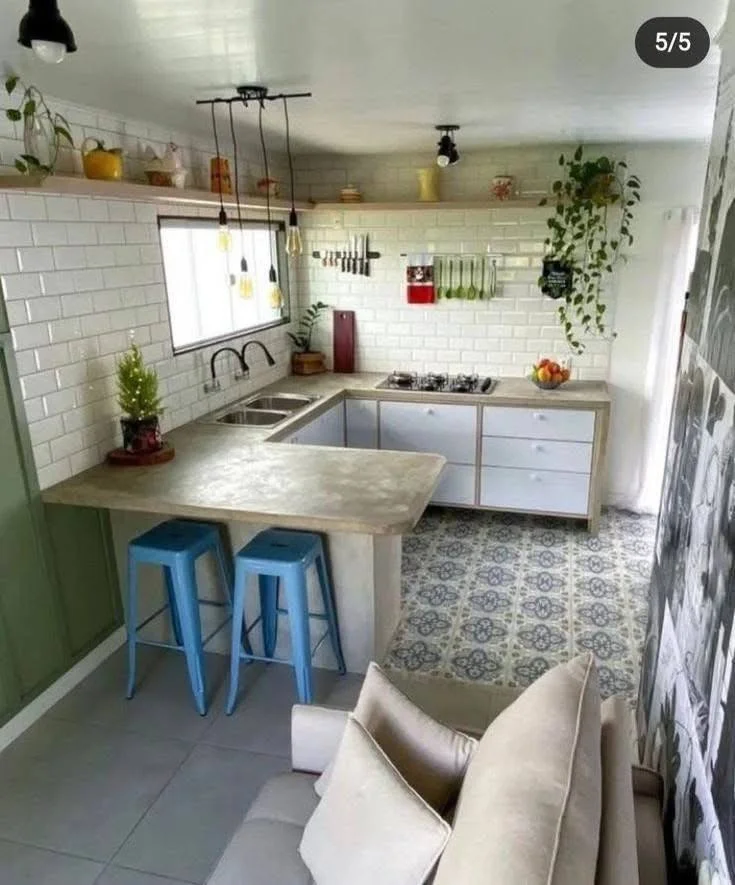 Compact kitchen with an L-shaped concrete countertop and colorful accents.