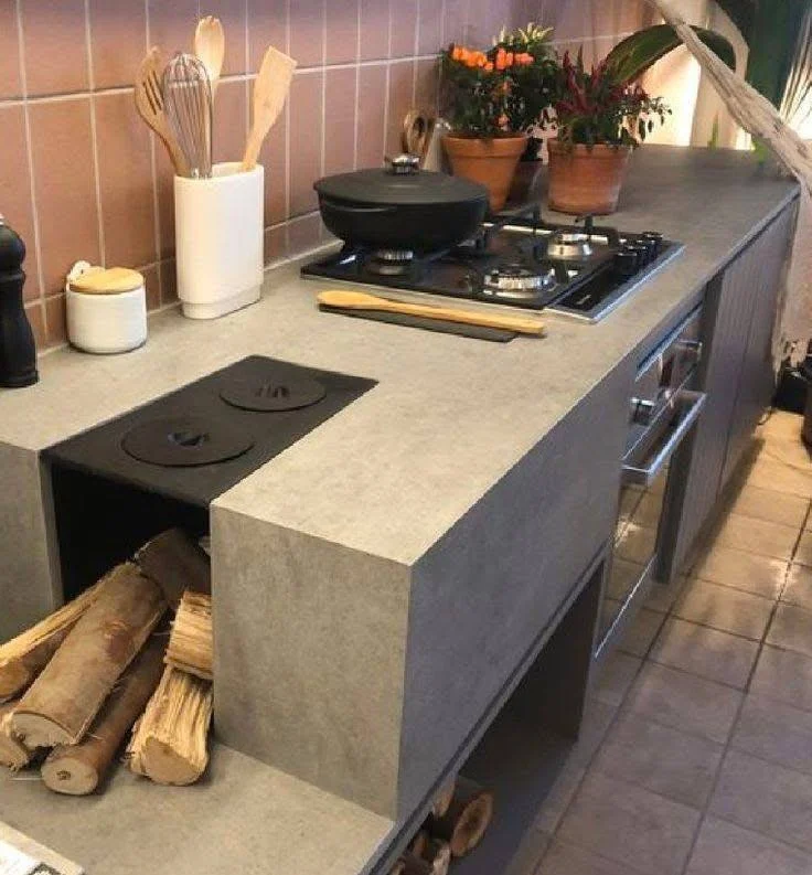 Modern kitchen with a concrete countertop and seamlessly integrated cooktop.