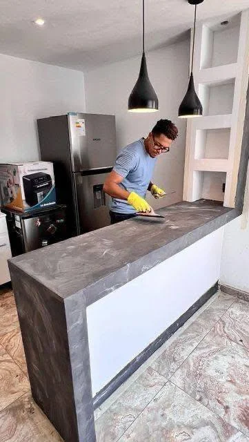 Two-toned concrete kitchen island with a light, polished top and darker, textured sides.  - concrete kitchen ideas