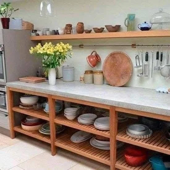 Kitchen featuring a concrete countertop with open wood shelving below.  - concrete kitchen ideas