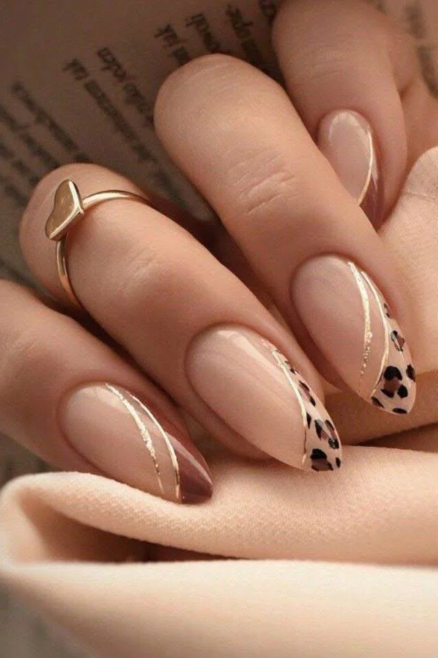 Almond-shaped nails with nude, taupe, and abstract leopard swirl design.