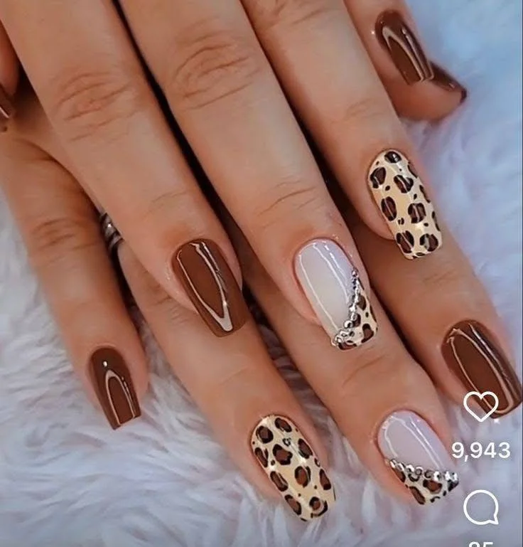 Chocolate brown nails with leopard print and rhinestone accents.