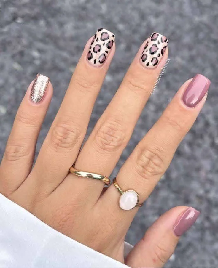 Mauve nails with leopard print and glitter accent nails.