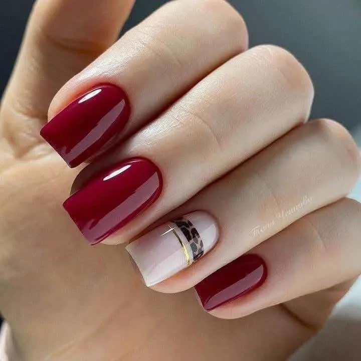 Red nails with a nude and leopard print stripe accent nail.