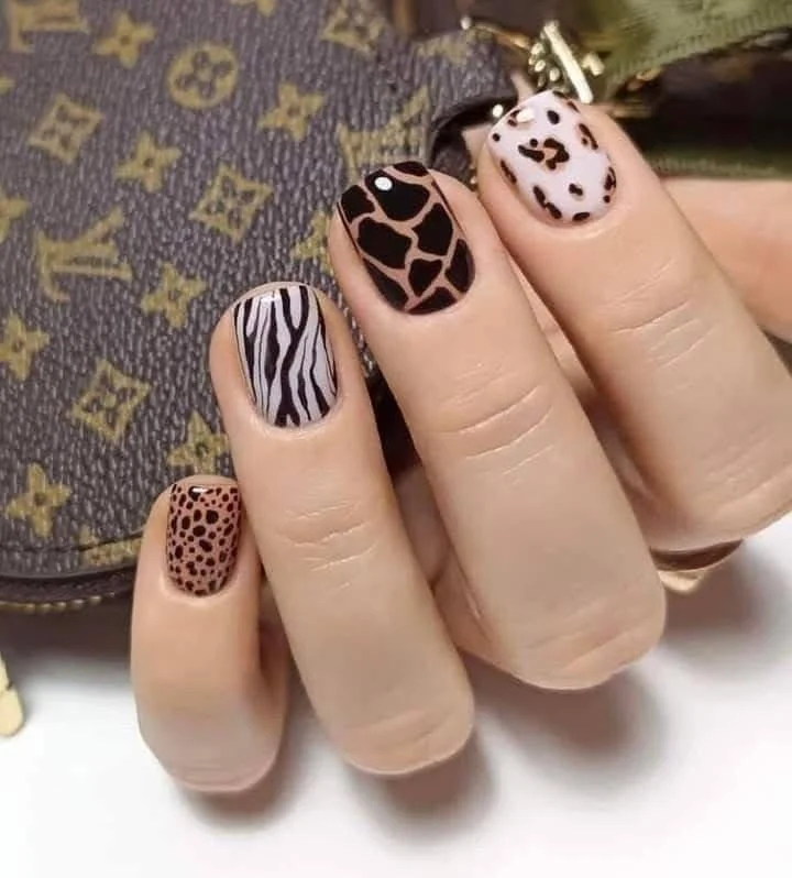 Mixed animal print nails with zebra, giraffe, and leopard patterns.