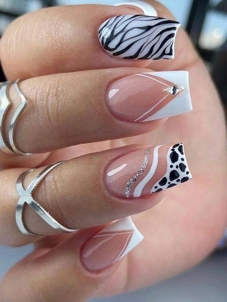 Zebra print, French tip, and glitter accent nails.