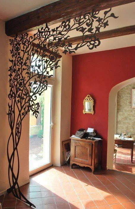 Artistic metal room divider separating living spaces.