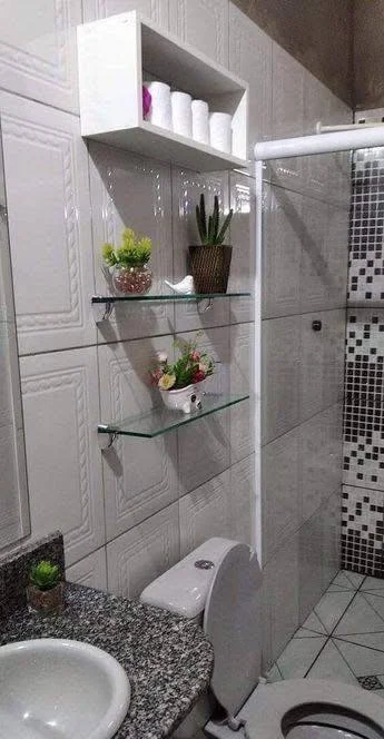 DIY glass shelves in bathroom for toiletries and decor.