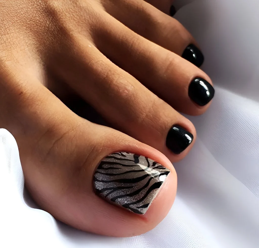 Silver zebra print accent toenail with other toes painted glossy black.