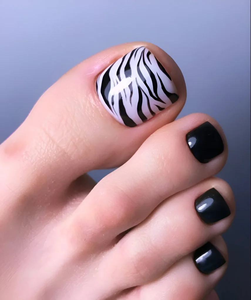 Full-coverage zebra print on the big toenail, other toes painted black.