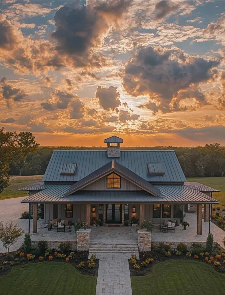 Farmhouse with symmetrical facade and metal roof at sunset.