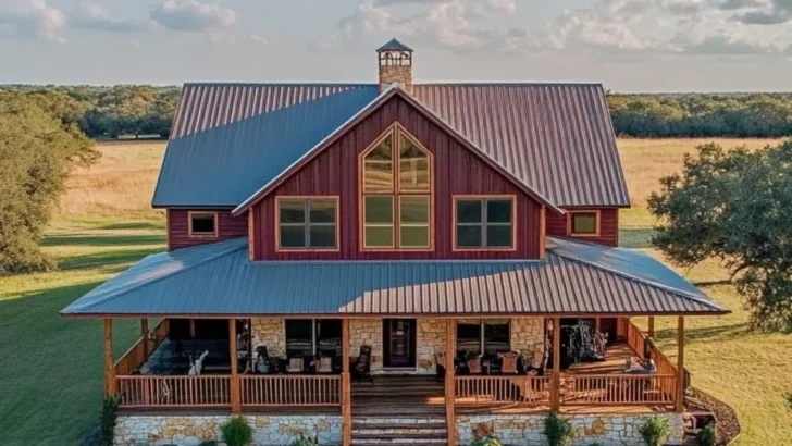 Farmhouse with large porch, gabled roof, and stone accents.