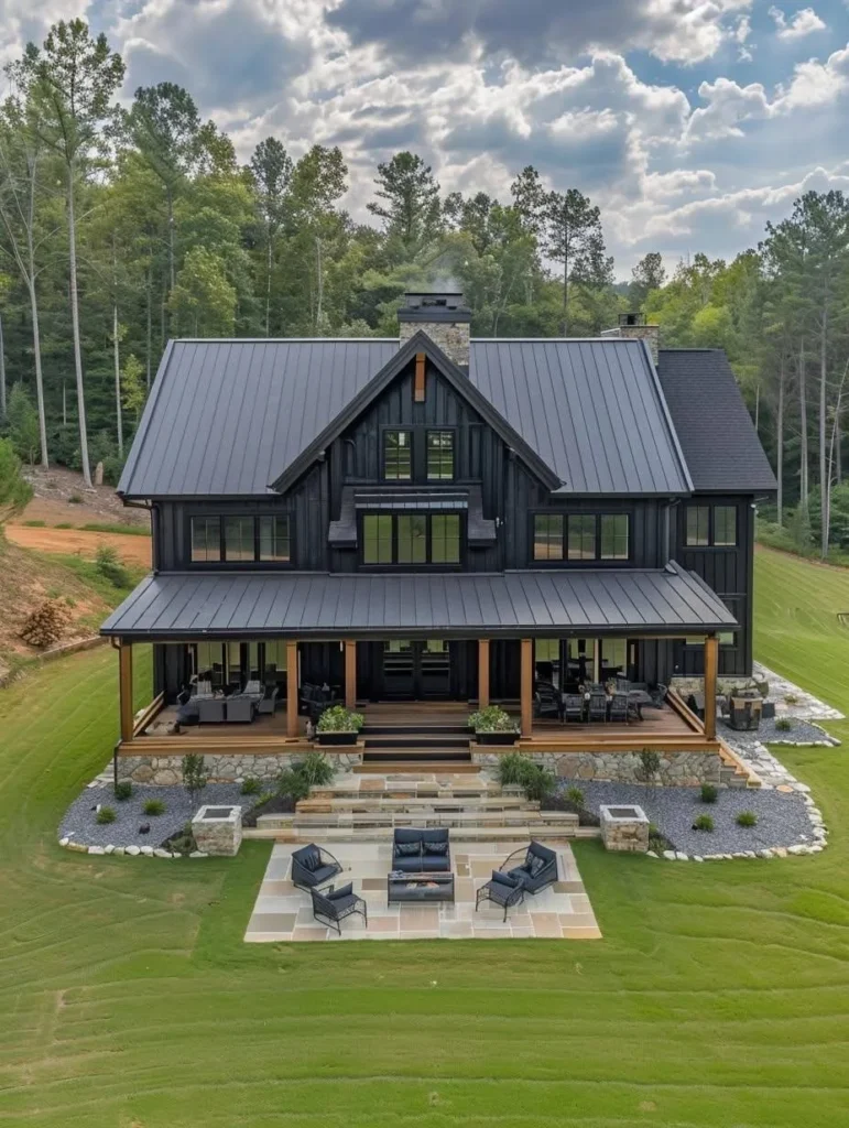 Dark-colored barndominium with large porch and stone patio.