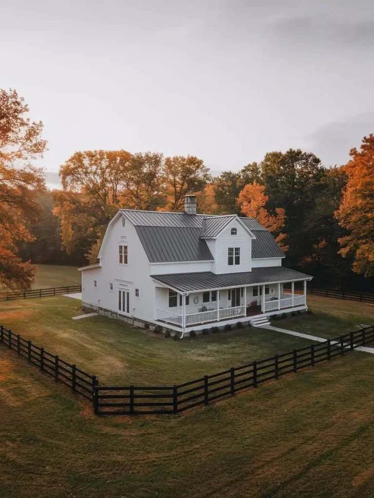 White Modern Barndominium Exterior with a dark fence and a wrap-around porch.