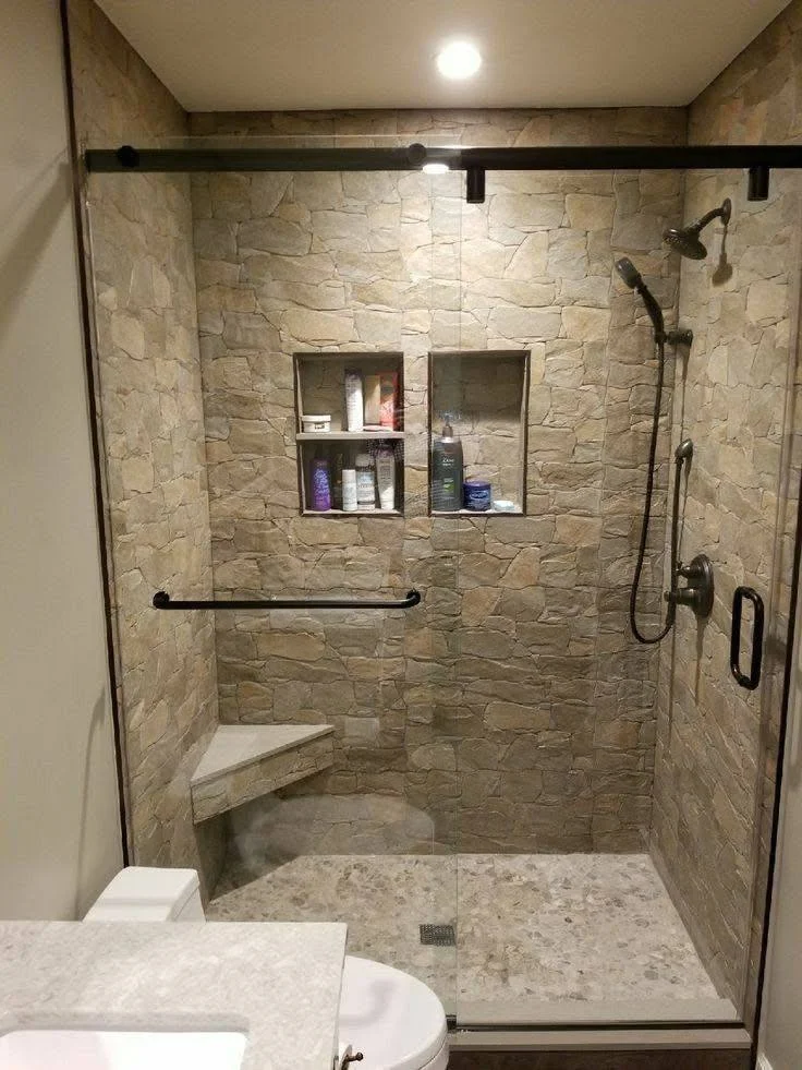 Modern bathroom with textured stone-look wall tiles and built-in niches.