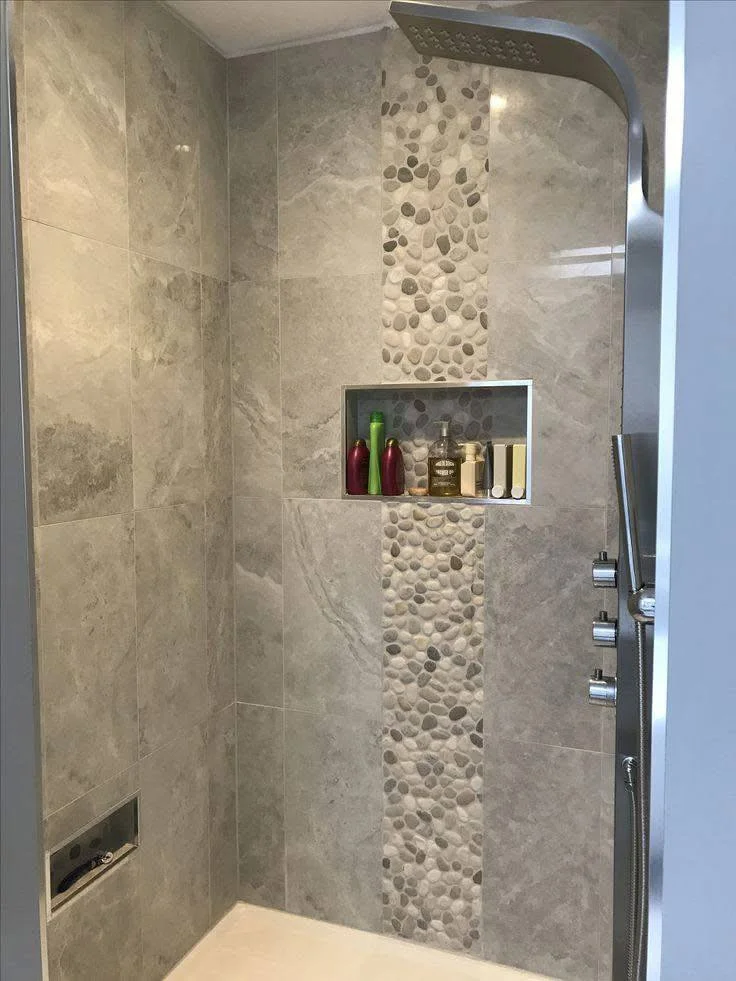 Modern bathroom shower with vertical pebble tile accent strip.