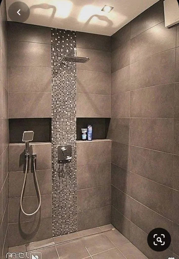 Modern bathroom shower with vertical mosaic tile accent strip.