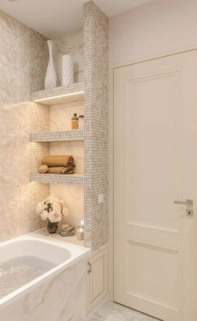 Modern bathroom with built-in shelves, backlighting, and light-toned tile.