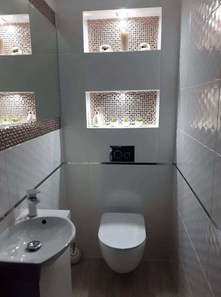 Modern bathroom with mirrored mosaic tile niches and white wall tiles.