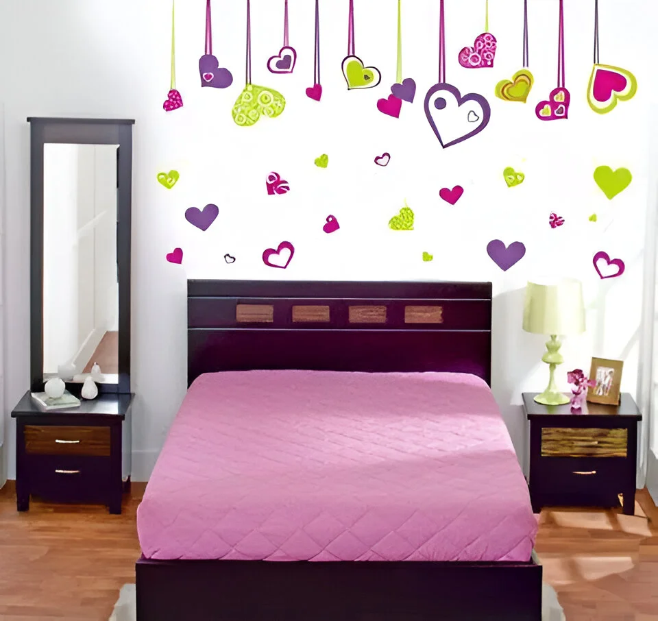 Bedroom wall decorated with colorful hanging heart decals.