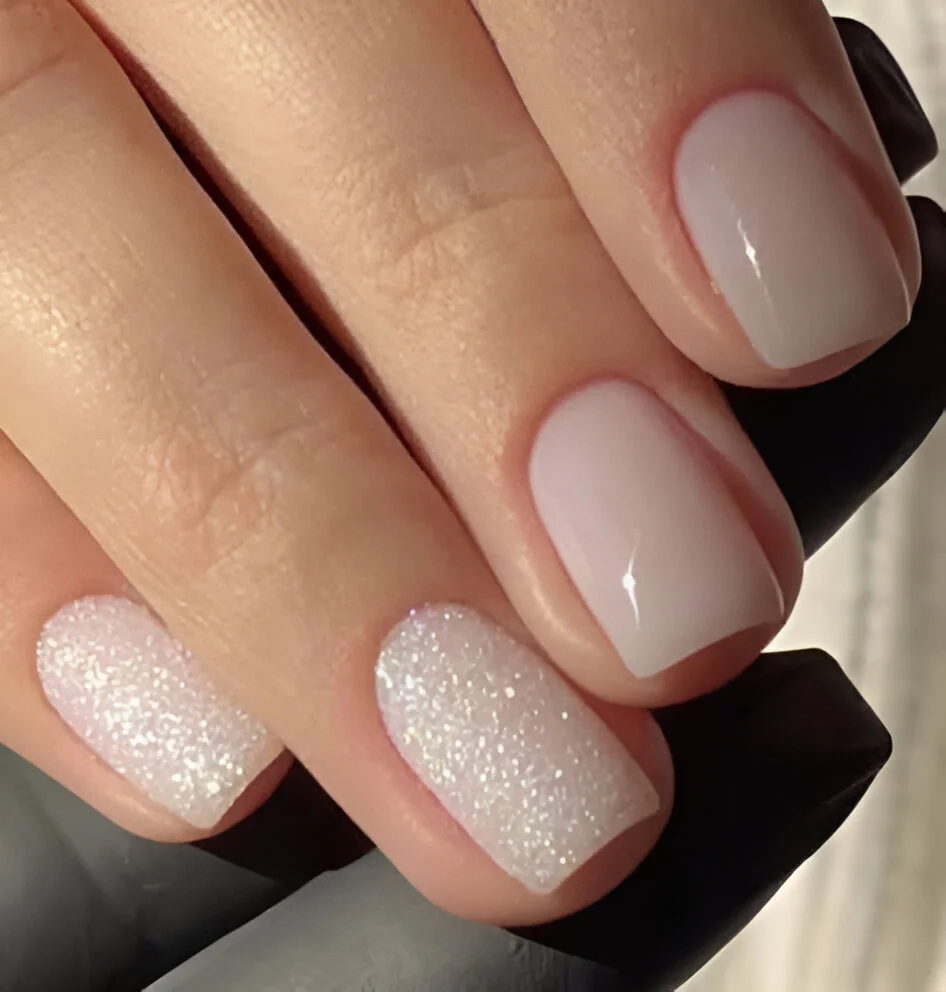 Light beige acrylic nails with a glossy finish and a sparkling white glitter accent nail - Classy Nails