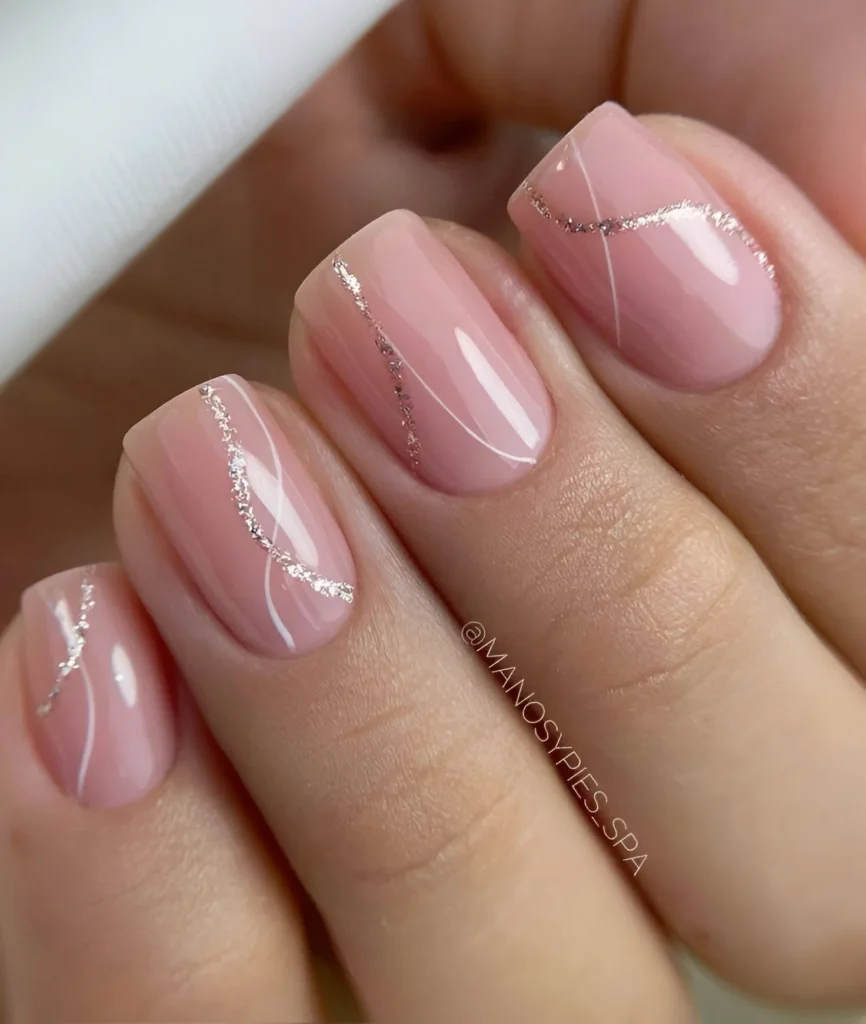 Blush pink nails with delicate, abstract silver line designs.