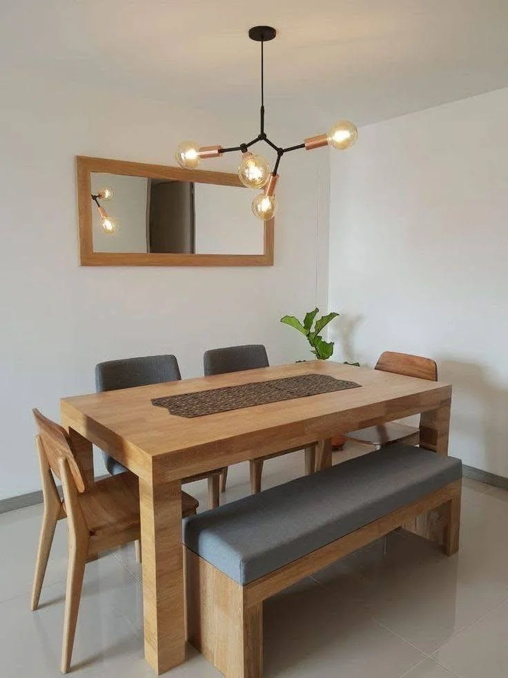 Dining room featuring a solid wood table, a bench, chairs, and an industrial-style chandelier.