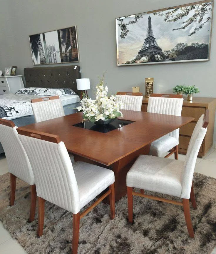 Dining room featuring a square table, upholstered chairs, and a defining area rug.