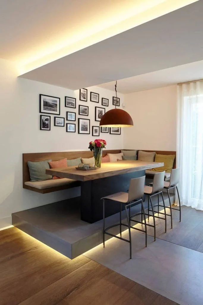 Modern dining room with an elevated banquette, gallery wall, and unique lighting.