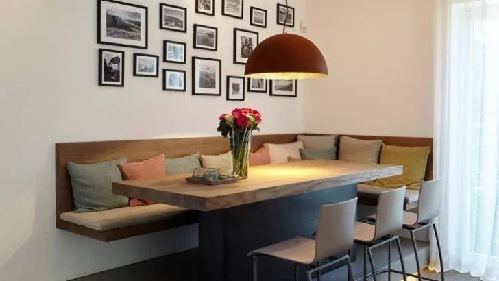 Modern dining room with an elevated banquette, gallery wall, and unique lighting.