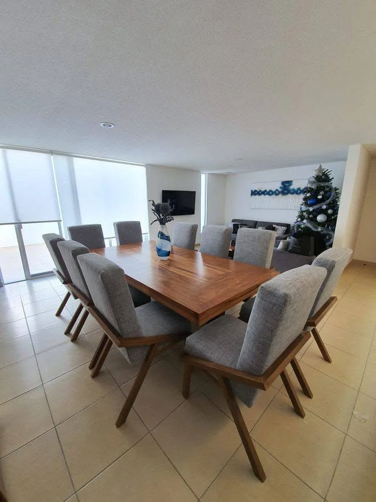 Dining room set with a mid-century modern flair, featuring angled legs and upholstered chairs.