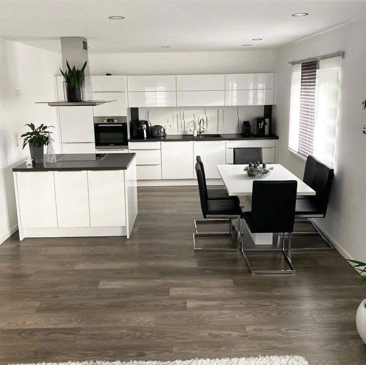 Modern black and white kitchen and dining area with a minimalist design.