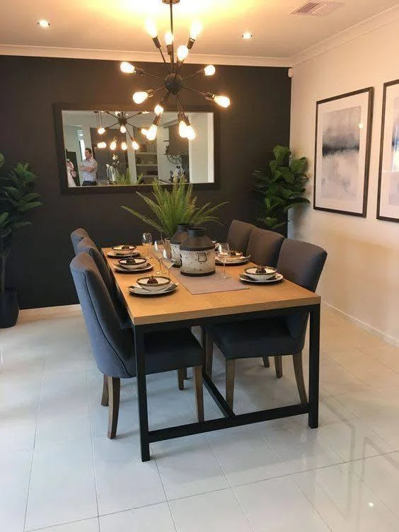 Dining room featuring an industrial-style table, a black accent wall, and a sputnik chandelier.