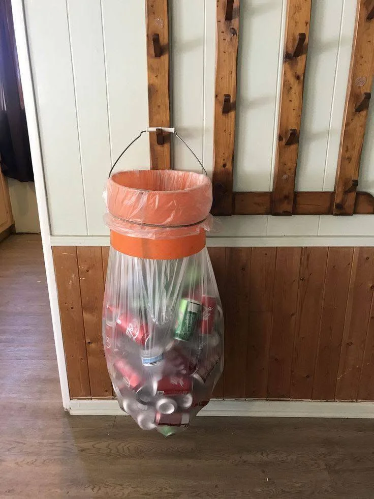 DIY recycling bag holder using a bucket and wire hanger.